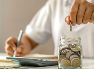 Jak oszczędzać na co dzień – kobieta planująca budżet z słoikiem oszczędności